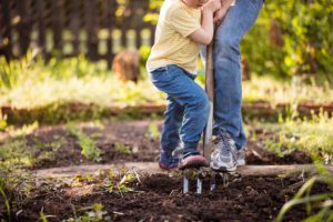 Femme et enfant en train de becher la terre du potager